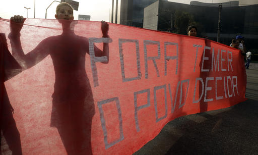 Demonstrators hold a banner that reads in Portuguese; "Temer out