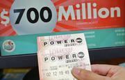A customer shows her purchased Powerball tickets for Wednesday's drawing