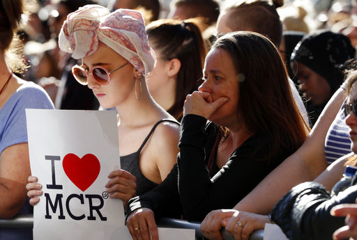 People attend a vigil in Albert Square