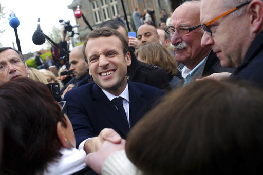 Centrist candidate Emmanuel Macron shakes hands with a supporter after casting his ballot in the first round of the French presidential election