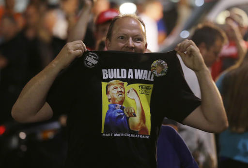 A supporter of Republican presidential candidate Donald Trump holds up his shirt