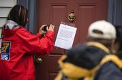 Members of the media make images of a posted note on the front door of Jim and Lyn Coleman's home in Stewartstown