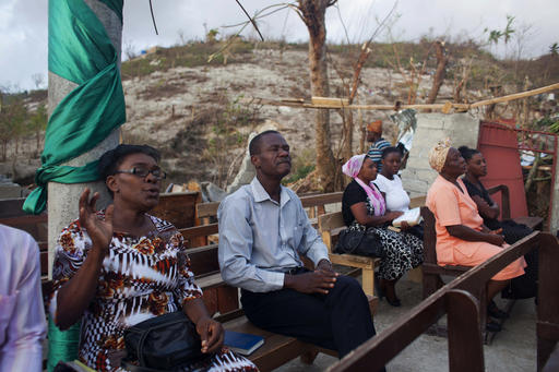 Residents pray at a church that was destroyed by hurricane Matthew in Jeremie