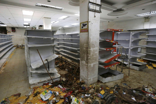 Destroyed merchandise is strewn on a supermarket floor around empty shelves
