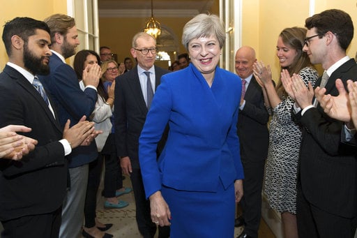 Britain's Prime Minister Theresa May and her husband Philip are applauded by staff as they return to 10 Downing Street
