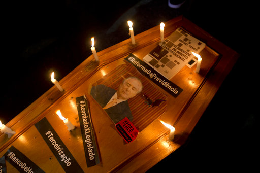 A mock coffin with a photo of Brazil's President Michel Temer is lit by candles during a protest in Rio de Janeiro