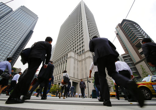 People walk in front of the headquarters building of Hitachi Ltd.
