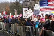 People line up on Central Park West as they wait for the start of a march highlighting equal rights and equality for women Saturday