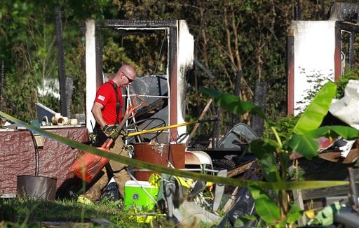 A firefighter with The Woodlands Fire Department works the scene of a two-story house fire that left multiple people dead Friday