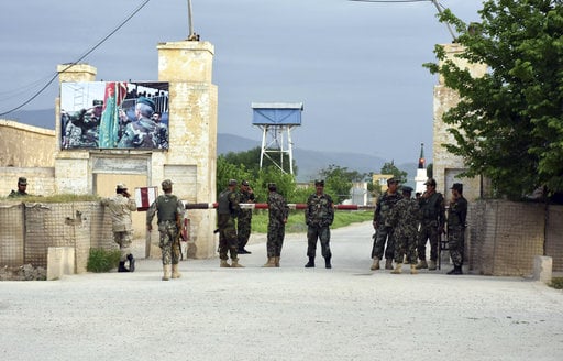 Afghan soldiers stand guard at the gate of a military compound after an attack by gunmen in Mazar-e- Sharif province north of kabul