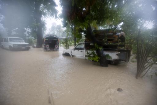 Vehicles sit stranded in flood waters in Leogane