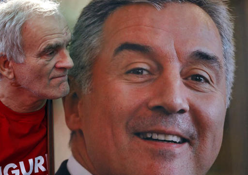 A supporter of Montenegro's Prime Minister and long-ruling Democratic Party of Socialists leader Milo Djukanovic holds his portrait during celebration after parliamentary elections