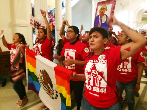 Demonstrators march in the Texas Capitol on Monday