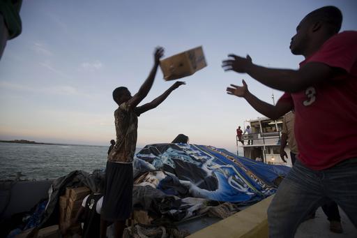 People unload food and water boated in from the "Mission of Hope" charity after Hurricane Matthew swept through Jeremie