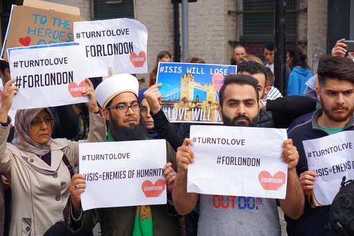 Muslims hold signs saying "ISIS WILL LOSE" and "#TURNTOLOVE" on Sunday June 4