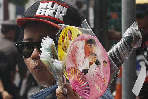 A Thai vendor sells commemorative fans as mourners gather to pay their respects to the late Thai King Bhumibol Adulyadej outside the Grand Palace in Bangkok