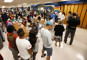 People at a Red Cross shelter set up at North Miami Beach Senior High School wait in line for lunch