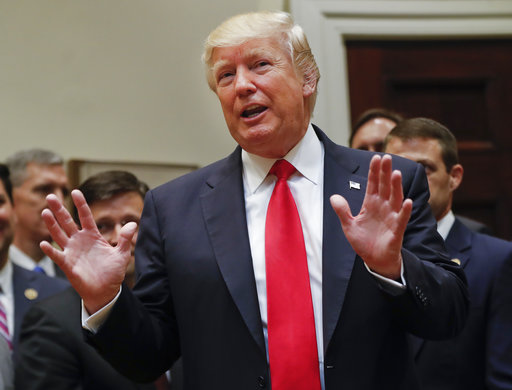 President Donald Trump gestures as he answers a question from a members of the the media after signing an Executive Order in the Roosevelt Room of the White House in Washington