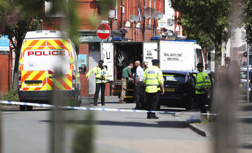 An army bomb disposal team works with members of the police in the Moss Side area of Manchester
