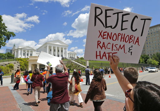 Protesters hold signs and march in front of the State Capitol across the street from the US 4th Circuit Court of Appeals in Richmond