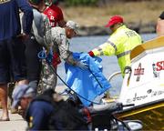 Water safety officials hand over possible debris from an Army UH-60 Black Hawk helicopter crash to military personnel stationed at a command center in a harbor