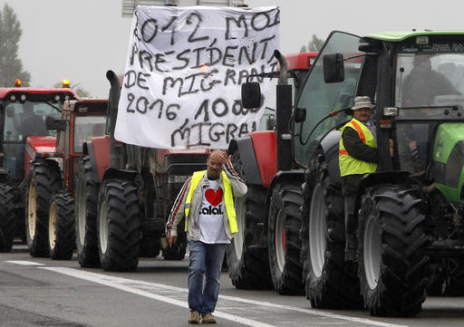 A farmer walks as others drive their tractors to block the highway leading to Calais and the Channel tunnel in Calais