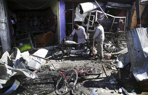 Men look at the remains of their properties at the site of a suicide attack in Kabul