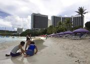 A family plays in the sand in Tumon