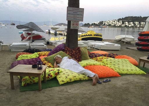 A man sleeps on the beachfront after spending the night outdoors following an earthquake in Bitez