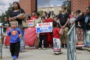 An unidentified child wears a Superman shirt in front of members of native American tribes who were holding a prayer during a rally outside the building where the Nebraska Public Service Commission was holding a hearing on the fate of the Keystone XL pipeline