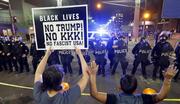 Protesters raise their hands after Phoenix police used tear gas outside the Phoenix Convention Center