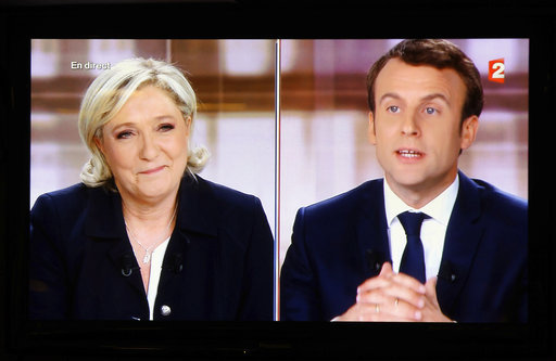 A television screen shows the live broadcast television debate with French centrist presidential candidate Emmanuel Macron