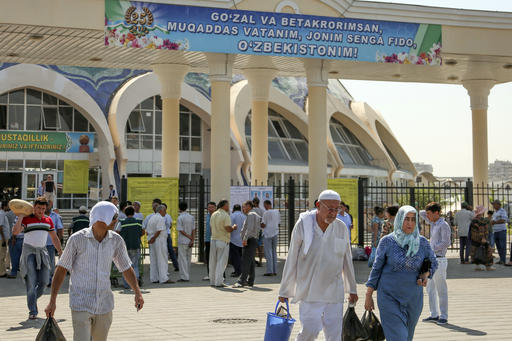 People walk at a central market in Tashkent