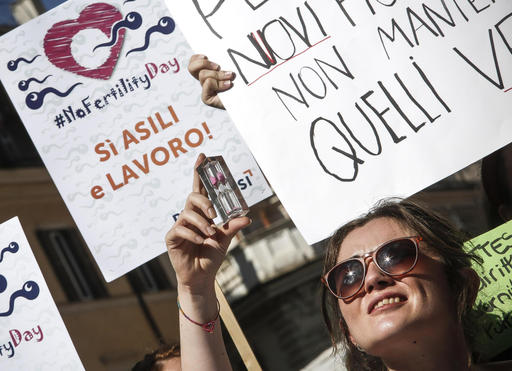 A woman holds up an hourglass during a protest in front of the Italian Health Ministry during the launch of a 'Fertility Day' campaign