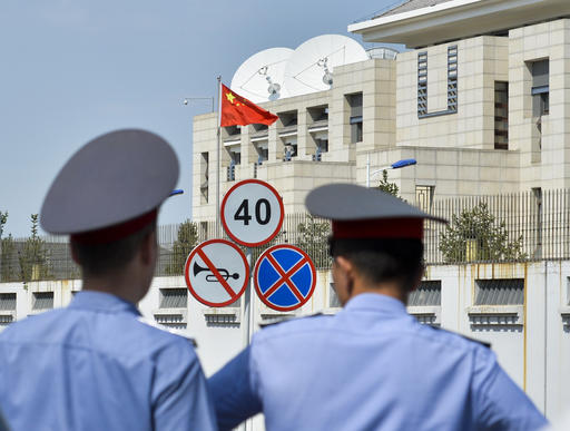 Kyrgyz police officers look at the Chinese Embassy in Bishkek