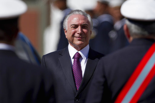Brazil's President Michel Temer smiles as he receives military honors during ceremony