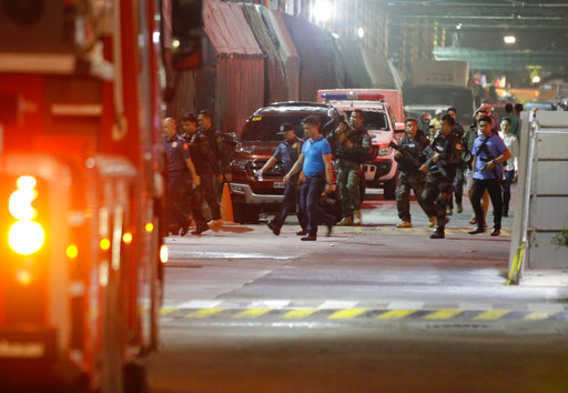 Armed security officers walk outside a hotel at the Resorts World Manila complex