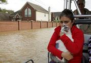 Jannett Martinez holds her cat Gigi as she rides a boat out of her neighborhood which was inundated after water was released from nearby Addicks Reservoir when it reached capacity due to Tropical Storm Harvey on Tuesday