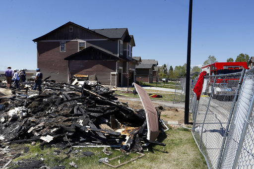 Workers dismantle the charred remains of a home at the location where an unrefined petroleum industry gas line leak explosion killed two people inside their home