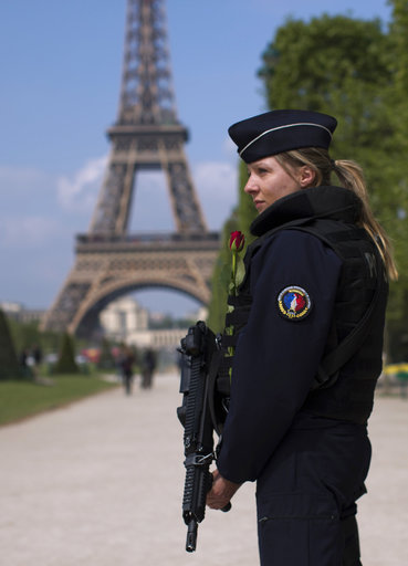 A French police officer patrols with the Eiffel Tower in background