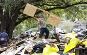 Rene Ramirez helps move debris from a home damaged by floodwaters in the aftermath of Hurricane Harvey on Wednesday