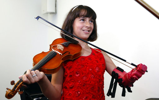Ten year old Isabella Nicola Cabrera smiles after playing her violin with her new prosthetic hand at the Engineering department of George Mason University in Fairfax