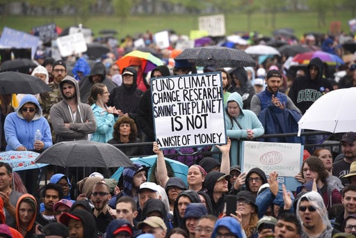 A person hold up a sign that reads "Fund Climate Change Research Saving The Planet Is Not A Waste Of Money" during the March for Science in Washington