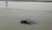 An abandoned vehicle sits in flood waters on the I-10 highway in Houston
