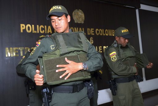 Police put on bulletproof vests before leaving a police station to patrol the streets of Medellin