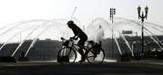 A bicyclists heads through downtown past the Salmon Street Springs fountain in Portland