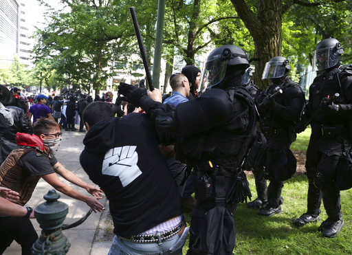 Police officers move to clear demonstrators from Chapman Square in downtown Portland