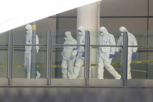 Police forensic investigators walk along a bridge linking Victoria Station with the Manchester Arena Tuesday