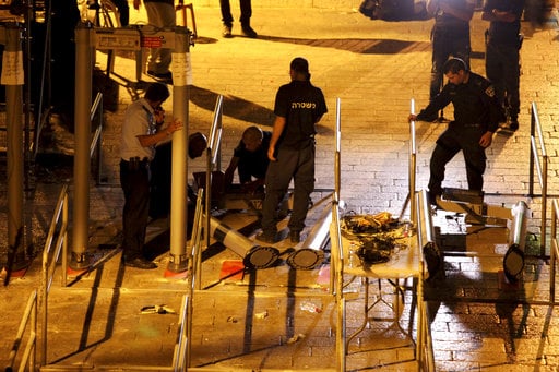Israeli police officers dismantle metal detectors outside the Al Aqsa Mosque compound in Jerusalem's Old City