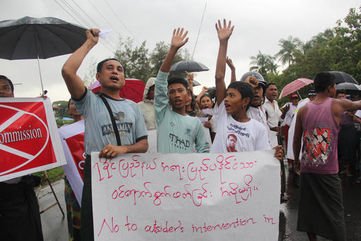 Hundreds of demonstrators hold banners and shout slogans in protest of the arrival of former United Nations Secretary-General Kofi Annan